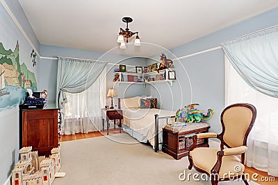 Kids bedroom interior in blue tones with cherry wooden furniture and nice curtains. Stock Photo