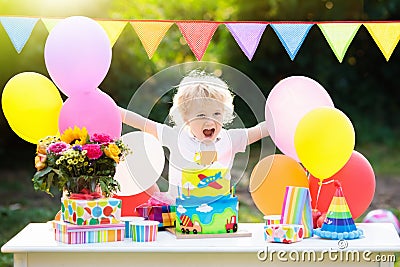 Kids birthday party. Child blowing out cake candle Stock Photo