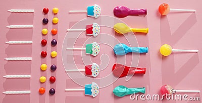 Kids birthday party decoration, pink background pattern. Colorful candies, bright balloon, festive candles, and paper straws Stock Photo