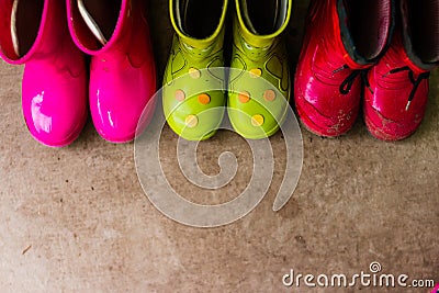 Kids bright pink, red, green rubber boots,gardening,boots. Rainy day fashion.Garden Rainy Rubber Shoes. boots for rainy Stock Photo