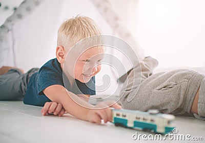Kids brothers are laying on the floor. Boys are playing in home with toy cars at home in the morning. Casual lifestyle Stock Photo