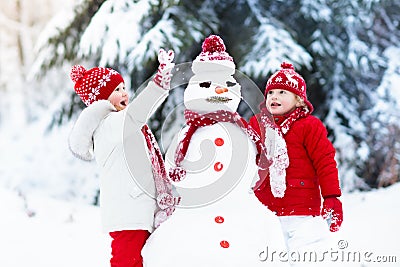 Kids building snowman. Children in snow. Winter fun. Stock Photo