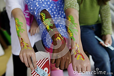Kids brightly painted arms at a carnival Stock Photo