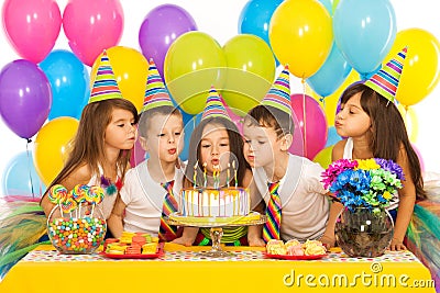 Kids celebrating birthday party and blowing Stock Photo