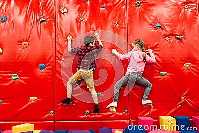 Kids climbing on a wall in attraction playground Stock Photo