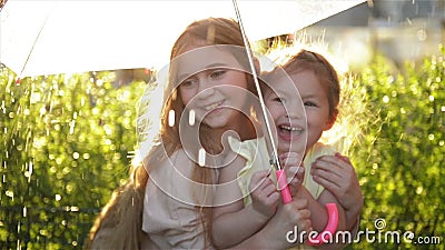 Kids with colorful umbrella playing in autumn shower rain. Little girls play in park by rainy weather. Fall outdoor fun stock video footage Kids with colorful umbrella playing in autumn shower rain. Little girls play in park by rainy weather. Fall outdoor fun stock video footage