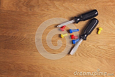 Kids construction toys tools: colorful screwdrivers, screws and nuts on wooden background. Top view. Flat lay. Copy Stock Photo