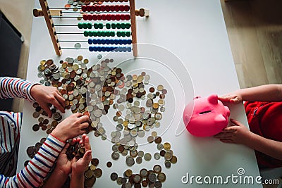 Kids count money, boy and girls put coins into piggy bank Stock Photo