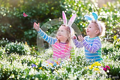 Kids on Easter egg hunt in blooming spring garden Stock Photo