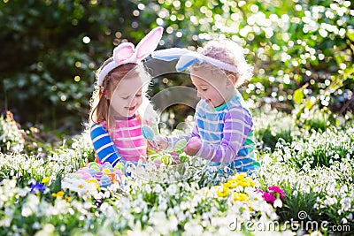 Kids on Easter egg hunt in blooming spring garden Stock Photo