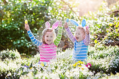 Kids on Easter egg hunt in blooming spring garden Stock Photo