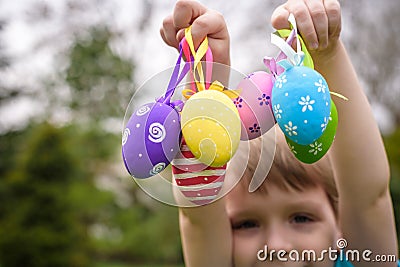 Kids on Easter egg hunt in blooming spring garden. Children searching for colorful eggs in flower meadow. Toddler boy and his brot Stock Photo