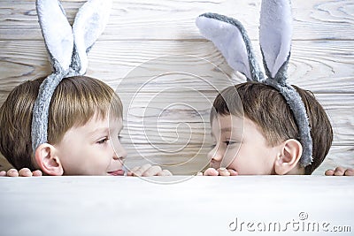 Kids on Easter egg hunt in blooming spring garden. Children searching for colorful eggs in flower meadow. Toddler boy and his brot Stock Photo