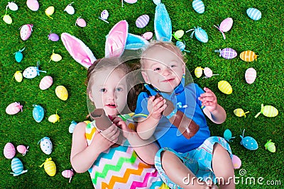 Kids eating chocolate rabbit on Easter egg hunt Stock Photo