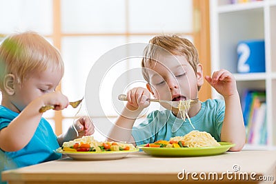 Kids eating healthy food in kindergarten or Stock Photo