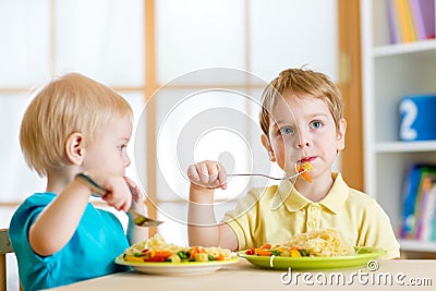 Kids eating in kindergarten or at home Stock Photo