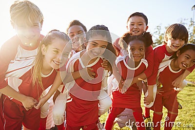 Kids in elementary school sports team piggybacking outdoors Stock Photo