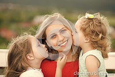 Kids enyoj happy day. Woman and girls sit on bench Stock Photo