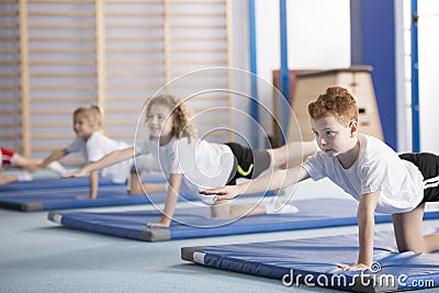 Kids exercising balancing yoga pose Stock Photo