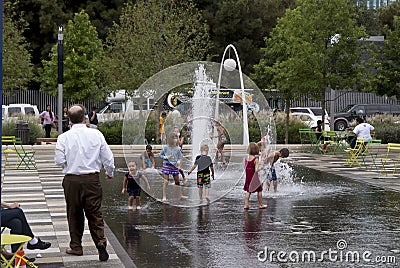 Kids in a fountain and parents watching them Editorial Stock Photo