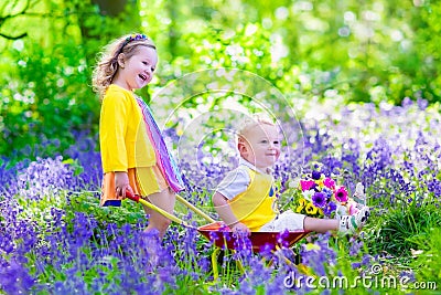 Kids in a garden with bluebell flowers Stock Photo