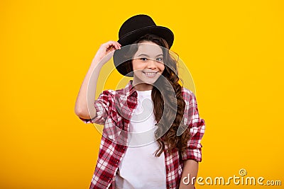 Kids girl in old fashion clothes. Elegent hat, cylinder hat isolated on yellow background. Headwear. Clothes accessories Stock Photo