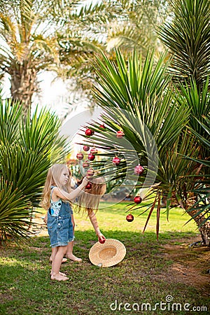 Kids girls dress up palm tree with Christmas toys Stock Photo