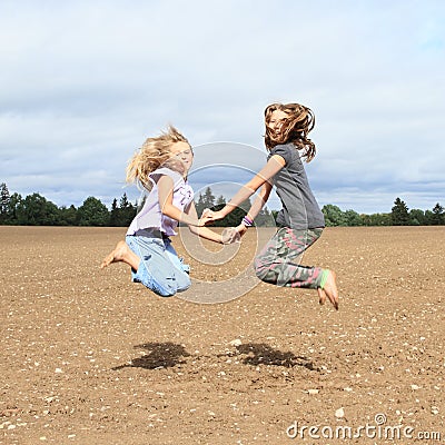 Kids - girls jumping on field Stock Photo