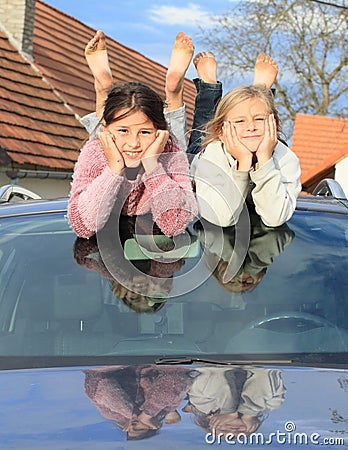 Kids - girls on windscreen of a car Stock Photo