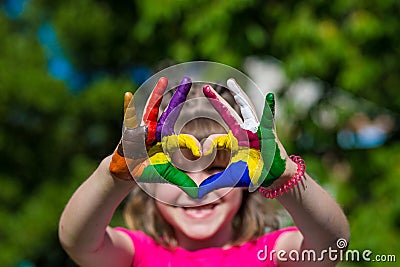 Kids hands in color paints make a heart shape, focus on hands Stock Photo