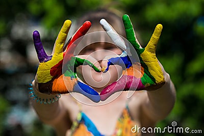 Kids hands in color paints make a heart shape, focus on hands Stock Photo