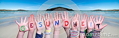 Kids Hands Holding Word Gesundheit Means Health, Ocean Background Stock Photo