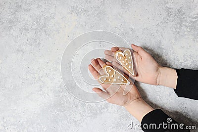 Kids hands holding couple of ginger bread heart cookies with white icing. Valentine or Mothers day holiday day Stock Photo