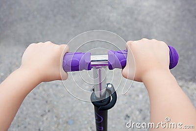 Kids hands holding handlebar on scooter Stock Photo