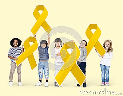 Kids holding gold ribbons supporting childhood cancer awareness Stock Photo