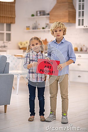 Kids holding red sign, demanding their rights Stock Photo