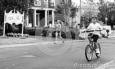 Kids and joggers on street of wealthy gated community neighborho Editorial Stock Photo