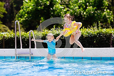 Kids jumping into swimming pool Stock Photo