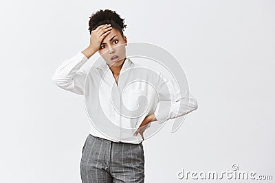 Kids like pain in ass. Portrait of displeased and tired sucessful businesswoman in suit, touching forehead and holding Stock Photo