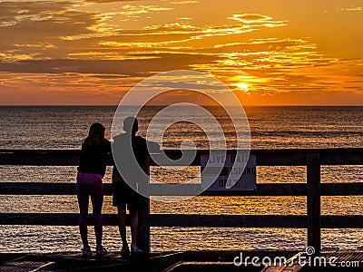 Kids looking at sunrise from the pier Editorial Stock Photo