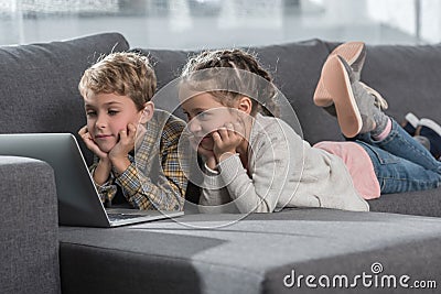 Preschooler children lying on a sofa with a Stock Photo