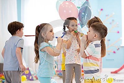 Kids with noisemakers making noise on party Stock Photo