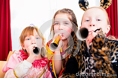 Kids with noisemakers making noise on party Stock Photo