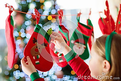 Kids opening Christmas presents. Child searching for candy and gifts in advent calendar on winter morning. Decorated Christmas Stock Photo