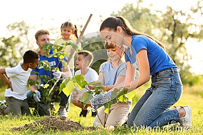 Kids planting trees with volunteers Stock Photo