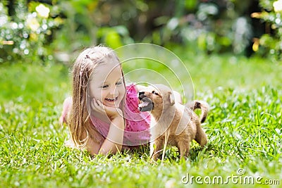 Kids play with puppy. Children and dog in garden. Stock Photo