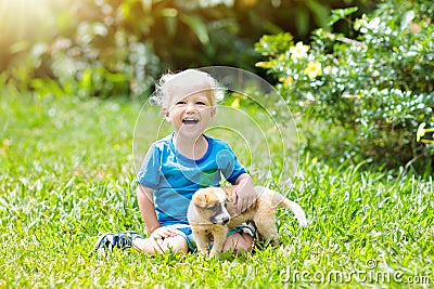 Kids play with puppy. Children and dog in garden. Stock Photo