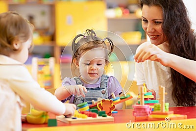 Kids play with shapes and colorful wooden puzzle in a montessori classroom Stock Photo