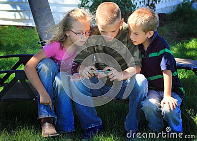 Kids playing on cell phone Stock Photo