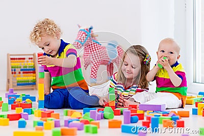 Kids playing with colorful toy blocks Stock Photo